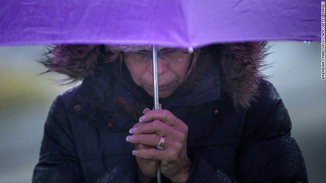 A woman bows her head in Newtown's Sandy Hook village on December 21.