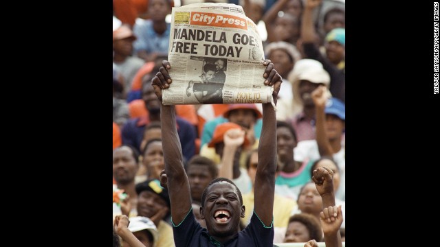 A jubilant South African holds up a newspaper announcing Mandela's release from prison at an ANC rally in Soweto on February 11, 1990. Two days later, more than 100,000 people attended a rally celebrating his release from jail.