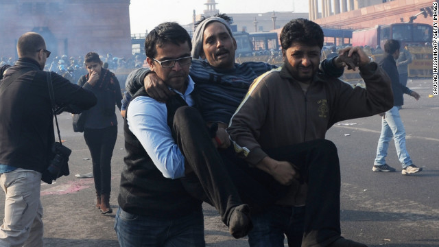 Indian demonstrators carry an injured man from the scene on December 22.