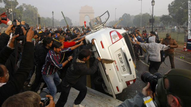 Demonstrators turn a car over on December 23.