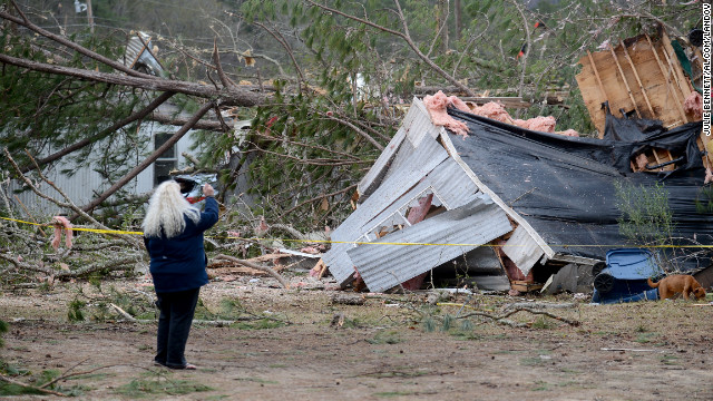 A woman takes a photo of a trailer home destroyed by a tornado near Troy, Alabama, on December 26.