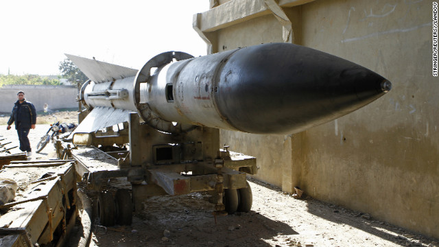 A man walks near a missile on Tuesday, December 25, at an army barracks outside Damascus, Syria, that has been taken over by the Free Syrian Army.