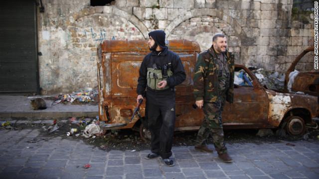 Free Syrian Army fighters stand near damaged cars in Aleppo on Thursday, December 27. 