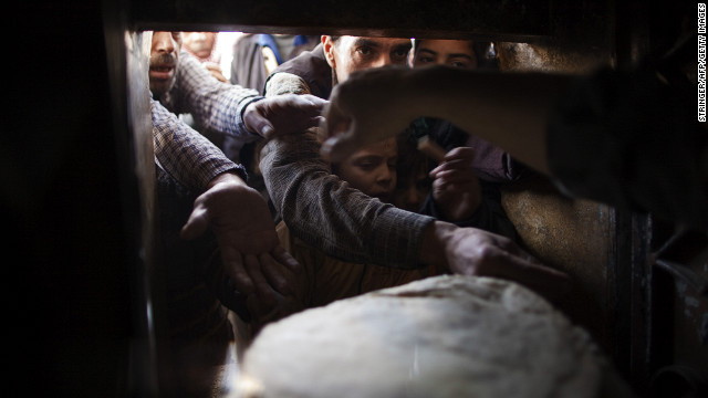 Syrians reach for bread at a bakery in Aleppo on Monday, December 31.