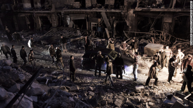 Syrians walk through debris in Aleppo after a missile hit a building January 7.
