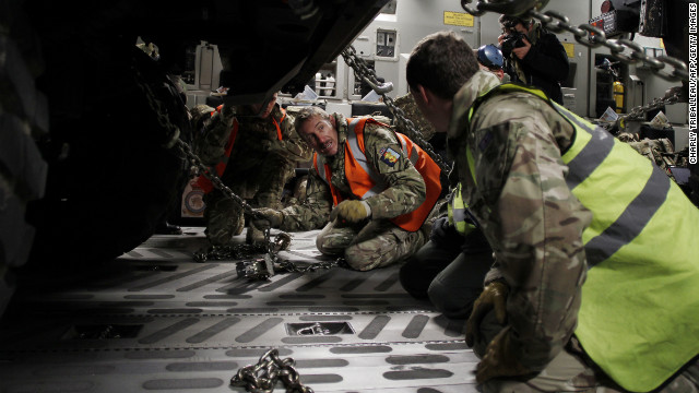 Workers adjust chains on a vehicle load in the C-17 in Evreux on Sunday.