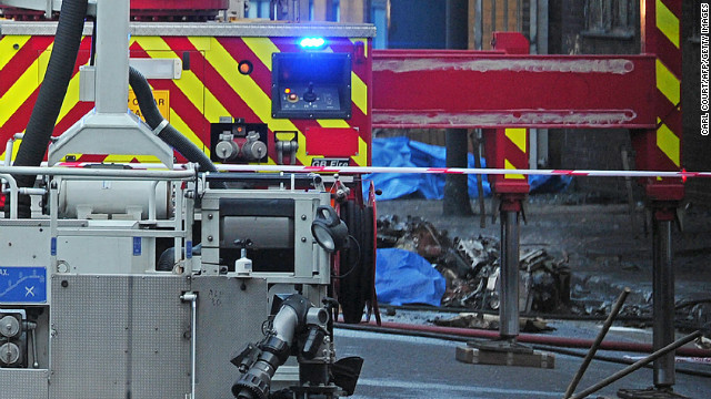 Debris is pictured beside a fire fighting vehicle at the scene of a helicopter crash.