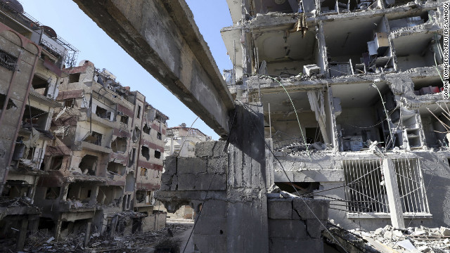 Men pass by buildings destroyed by Syrian air force air strikes in the Duma neighborhood of Damascus on Thursday, January 17. 