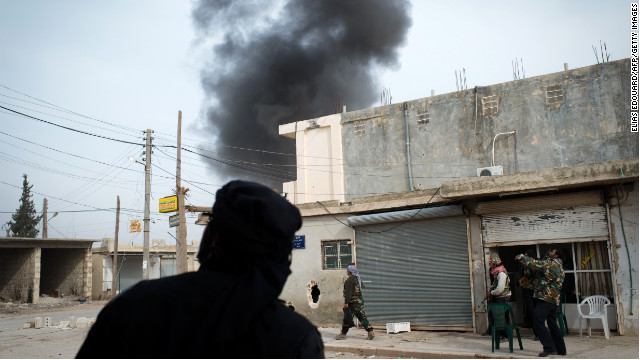 Fighters watch smoke rising from a bombing in Aleppo on January 18.