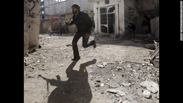 A rebel fighter runs for cover in Damascus on January 19.