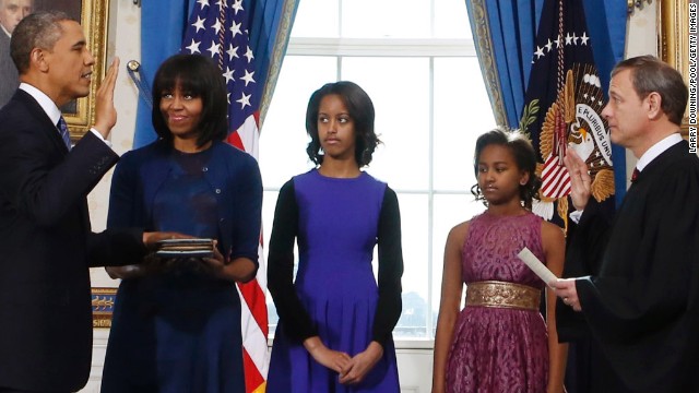 President Barack Obama takes the oath of office from U.S. Chief Justice John Roberts, as first lady Michelle Obama holds the Bible and daughters Malia, 14, and Sasha, 11, look on in the Blue Room of the White House on Sunday, January 20. Both Obama and Vice President Joe Biden were officially sworn in Sunday, with a public ceremony on Monday.