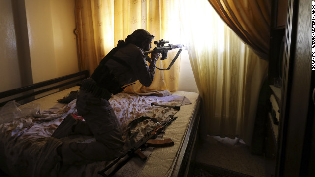 A Free Syrian Army fighter fires from inside a house during heavy fighting in Damascus on January 22. 