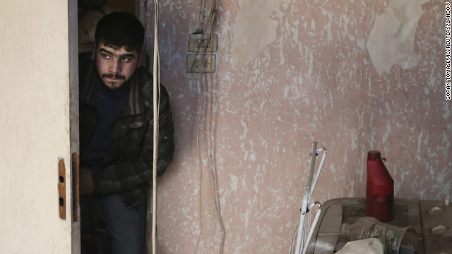 A Free Syrian Army fighter moves inside a house in Haresta neighborhood of Damascus on Sunday, January 20.