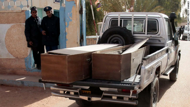 Algerian security personnel watch as empty coffins are transported to collect the victims killed at the In Amenas gas facility.
