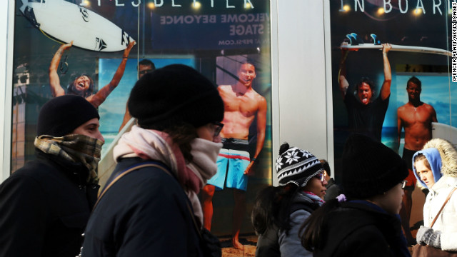 A surfer store with guys in swimwear seems an especially cruel sight for these bundled-up New Yorkers on Tuesday, January 22, as frigid temps hit the region. 