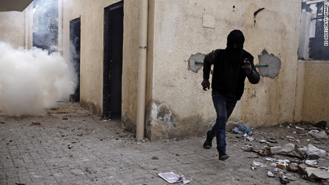 An Egyptian protester runs away from a cloud of tear gas fired by Egyptian riot police on January 26, in Cairo. 