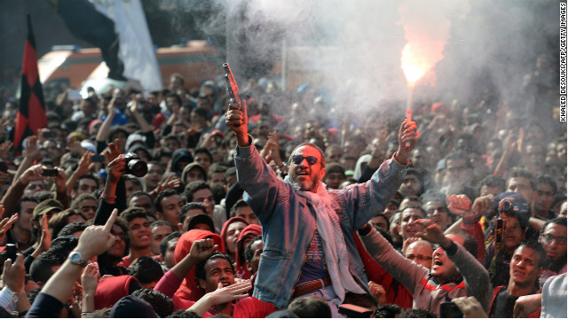 An Egyptian fan of Al-Ahly football club fires celebratory shots in the air and lights a flare as club supporters celebrate outside its headquarters in Cairo on January 26.