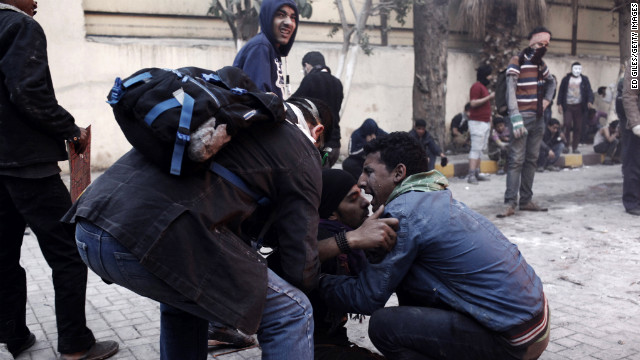 An Egyptian protester tries to carry an injured man away from clashes with riot police on January 26, in Cairo.