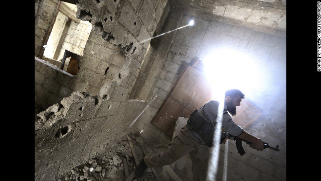 A rebel fighter fires back at Syrian army soldiers in Damascus on January 26.