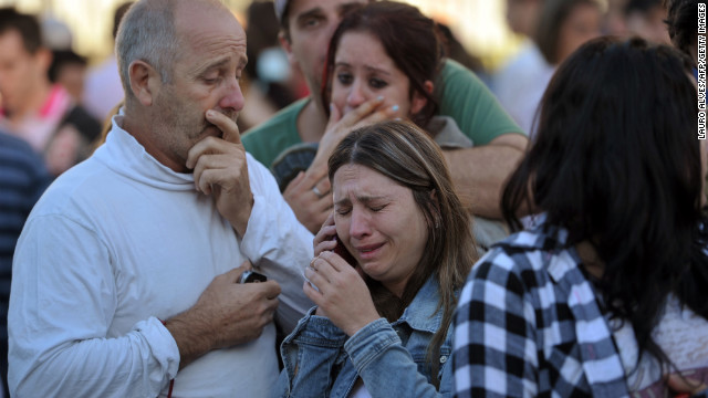 A grieving woman talks on her cell phone after the fire.