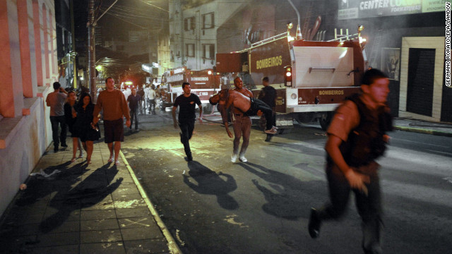 A firefighter, center, carries a victim away from the blaze.