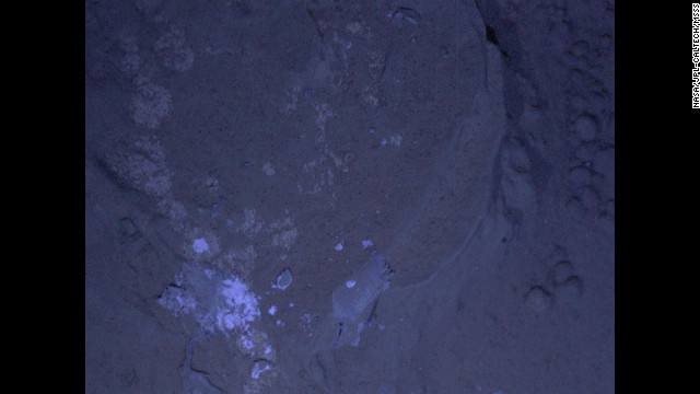 NASA's Mars rover Curiosity has taken its first set of nighttime photos, including this image of Martian rock illuminated by ultraviolet lights. Curiosity used the camera on its robotic arm, the Mars Hand Lens Imager, to capture the images on January 22.