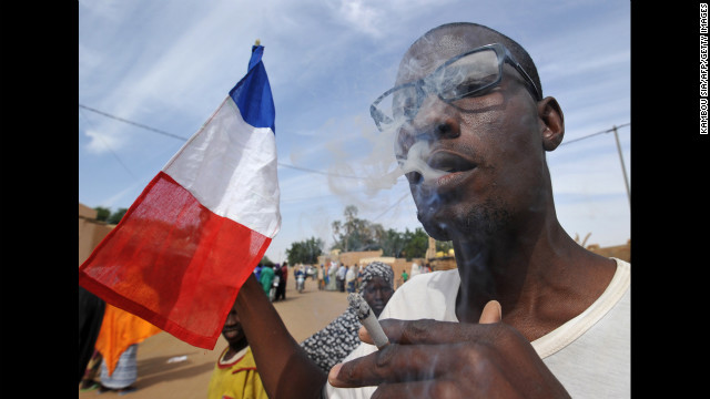 A man waves a French flag as residents celebrate the arrival of Niger troops on January 29 in Ansongo.
