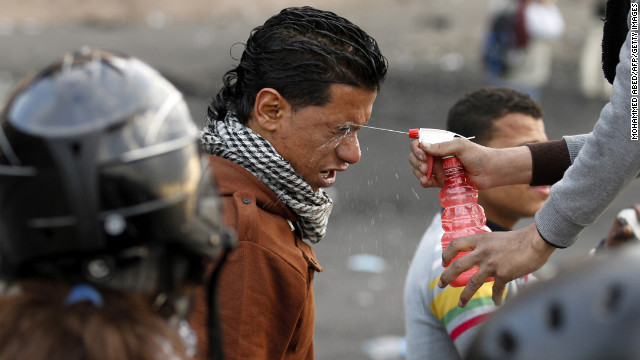 A protester sprays water into the eyes of a man after his exposure to tear gas during clashes with police near Cairo's Tahrir Square on Tuesday, January 29.