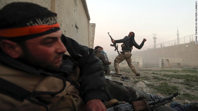 A rebel fighter throws a hand grenade inside a Syrian Army base in Damascus on February 3.