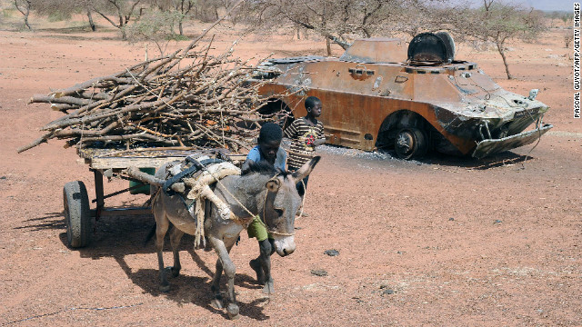 A child leads a donkey cart past a destroyed Malian army armored vehicle near Douentza, Mali, on February 5. 