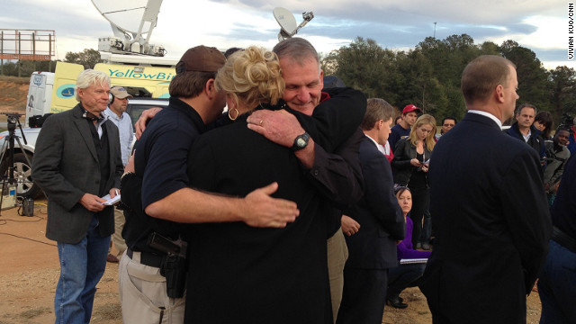 Dale County Schools Superintendent Donny Bynum hugs Dale County Sheriff Wally Olson and an unidentified woman after the standoff.