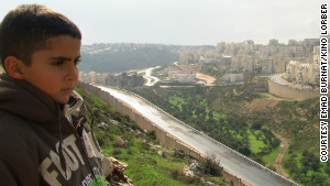Emad\'s son Gibreel looks over at the Israeli settlements