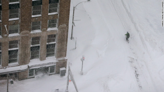 A cyclist rides through the snow in the Back Bay neighborhood of Boston.