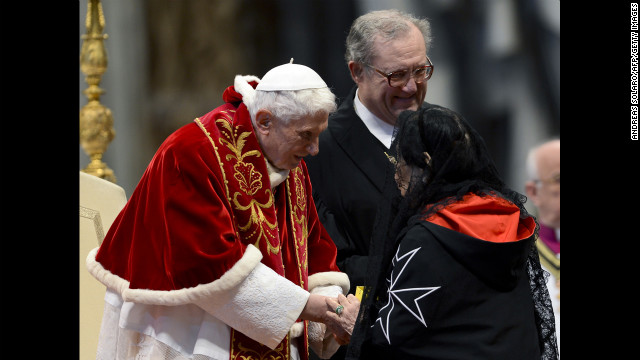 Benedict, accompanied by Grand Master Matthew Festing of the Sovereign Military Order of Malta, right, shakes hands with a woman after the Mass in St. Peter's Basilica to mark the 900th anniversary of the Order of the Knights of Malta on February 9, 2013, at the Vatican. 