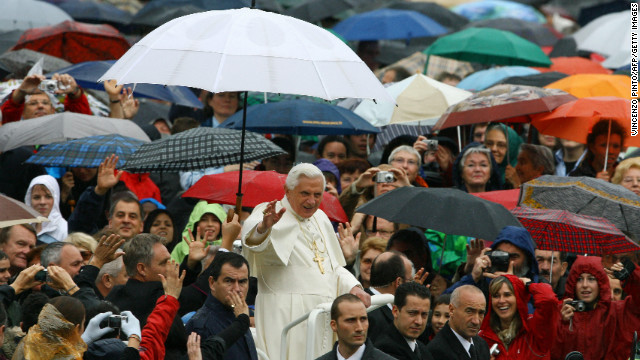 Benedict waves from under an umbrella as he arrives to lead his weekly general audience in Saint Peter's Square at the Vatican in October 2007.