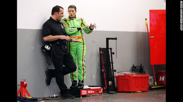 Patrick speaks to a crew member in the garage at Daytona International Speedway in 2012.