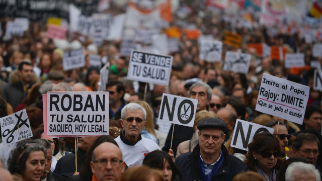 Protesters hold placards as they take part in a demonstration against plans to cut medical spending and privatize hospital services in Madrid on February 17. 