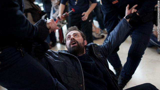 Riot police pull at a worker protesting from Spanish Airline Iberia during a rally against job cuts at Barajas Airport.