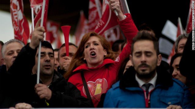 Staff from Spanish Airline Iberia hold flags and gather in protest against job cuts.