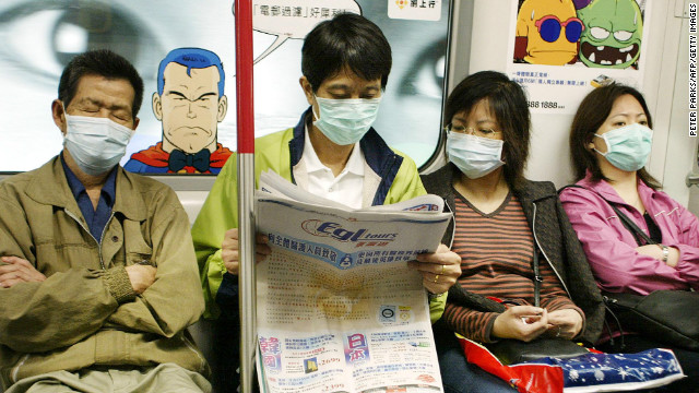 Subway passengers wear masks to protect against SARS on Hong Kong's MTR, April 4, 2003.