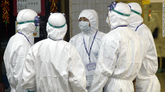 Health workers stand outside Block E of Amoy Gardens on April 8, 2003.