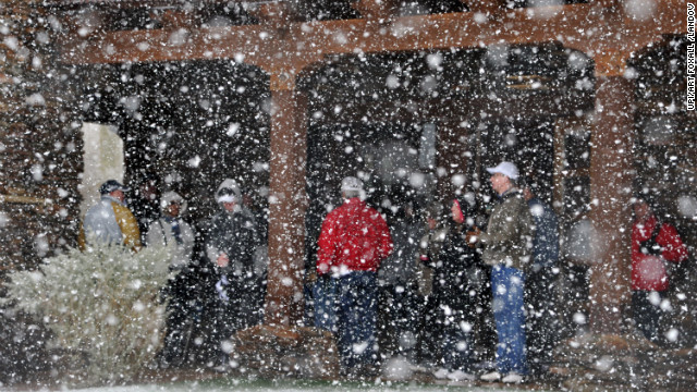Golf fans seek shelter from the snow Wednesday after the first round of the Accenture Match Play Championship at Dove Mountain in Marana, Arizona. The tournament was suspended due to the weather.