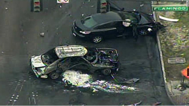 A burned tax and another vehicle involved in a shooting and collision sit on the Las Vegas Strip on Thursday.