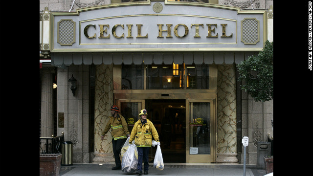 Firefighters leave the Cecil Hotel after removing the body.