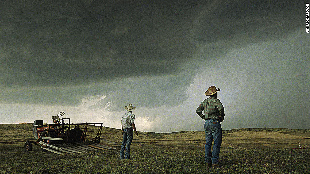 The "Greatest Photographs of the American West" exhibit is currently touring the United States. Here, workers in Nebraska halt haying to watch as afternoon thunderheads fill the sky. 