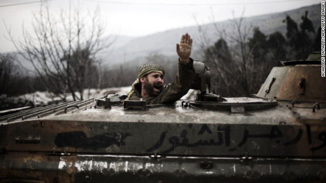 A Syrian rebel gestures at comrades from inside a broken armored personnel carrier in Al-Yaqubia on February 6.