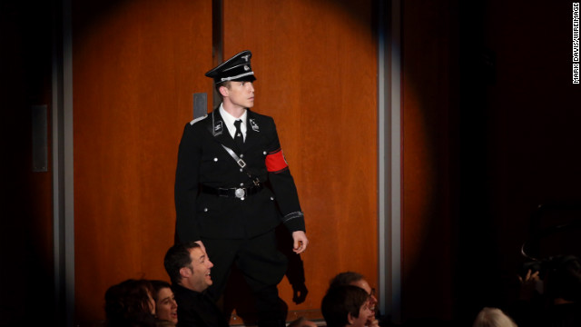 MacFarlane tries to introduce the Von Trapp family from "The Sound of Music," but an actor dressed as a Nazi runs into the auditorium and announces they're gone. Laughter ensues.