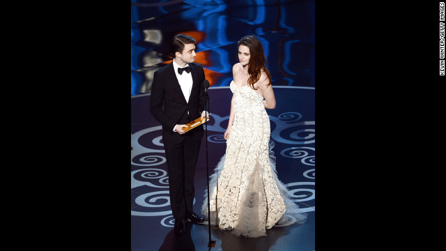 "Harry Potter's" Daniel Radcliffe and "Twilight's" Kristen Stewart present the award for best production design. Stewart, who was photographed using crutches on the red carpet, had to limp to the microphone.