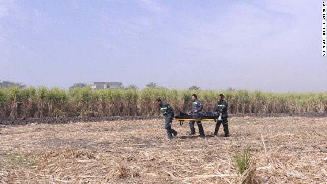 An ambulance crew carries the body of a tourist who died in the crash.