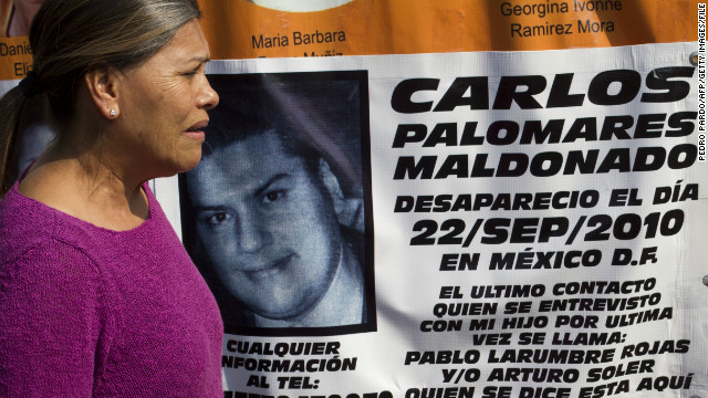 Ana Maria Maldonado stands by a banner for her missing son during a protestlast November in Mexico City.